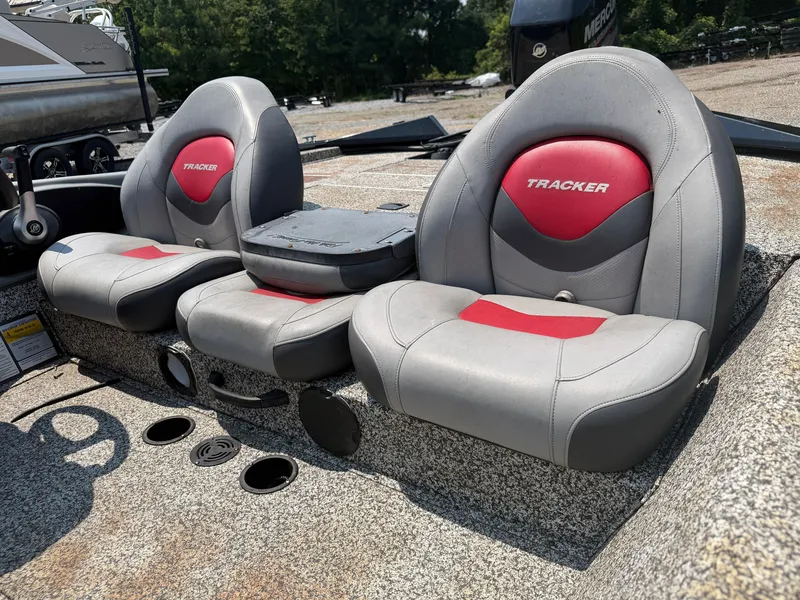 Slide: The Image of Two gray and red seats in a boat, featuring "Tracker" logo, on a gravel surface. - 13