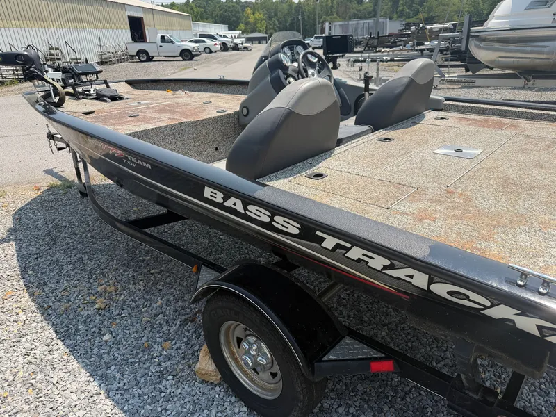Slide: The Image of A 2015 Tracker Pro Team 175 TXW bass boat on a trailer in a gravel lot. - 14