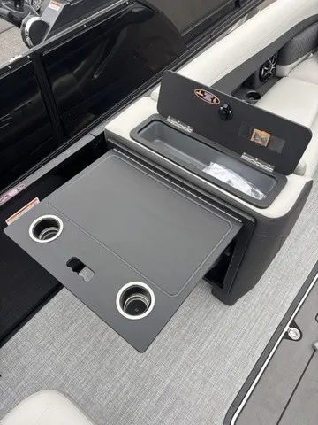 Slide: The Image of The image shows part of the interior of a 2027 Harris SUNLINER 230 SLDH. There's a fold-out table with cup holders and cushioned seating. - 9