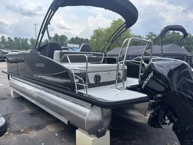 Slide: The Image of A Harris SUNLINER 230 SLDH pontoon boat with a black outboard motor, parked on a lot. - 4