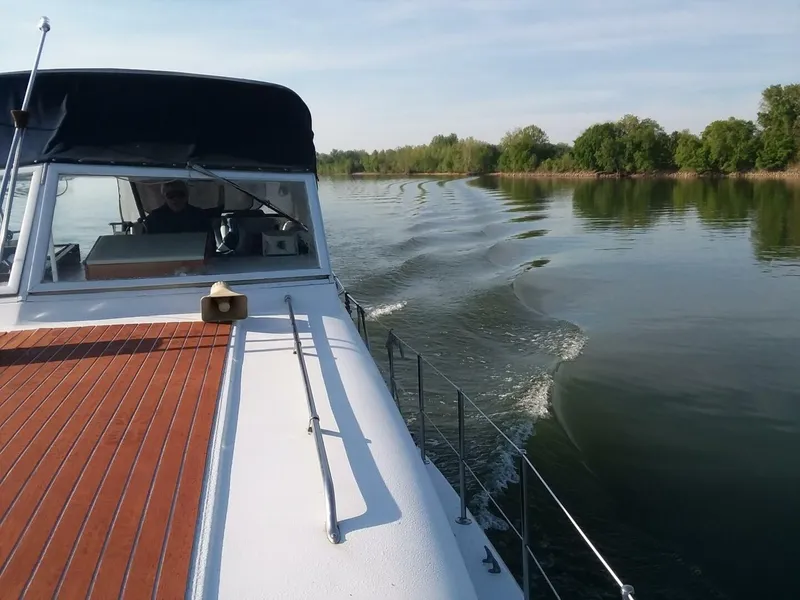 Slide: The Image of A 1979 Chris-Craft 350 Catalina cruising on a calm river, surrounded by trees. - 3