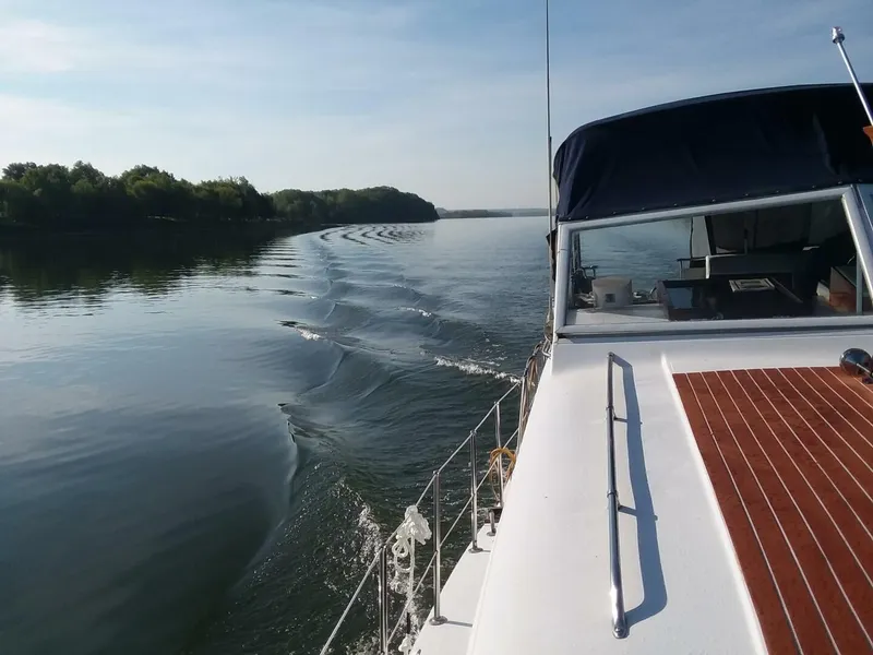 Slide: The Image of A 1979 Chris-Craft 350 Catalina cruising on a calm river with wooded banks. - 2
