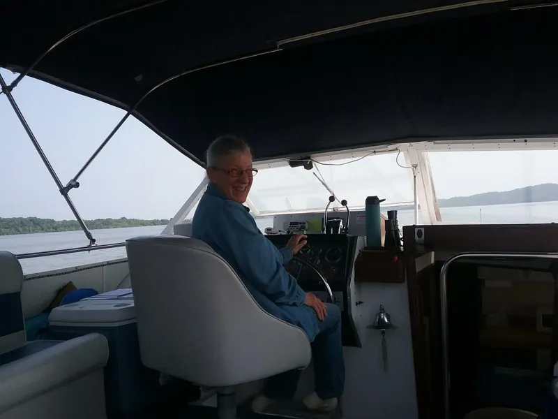 Slide: The Image of A person sits at the helm of a 1979 Chris-Craft 350 Catalina boat. - 23