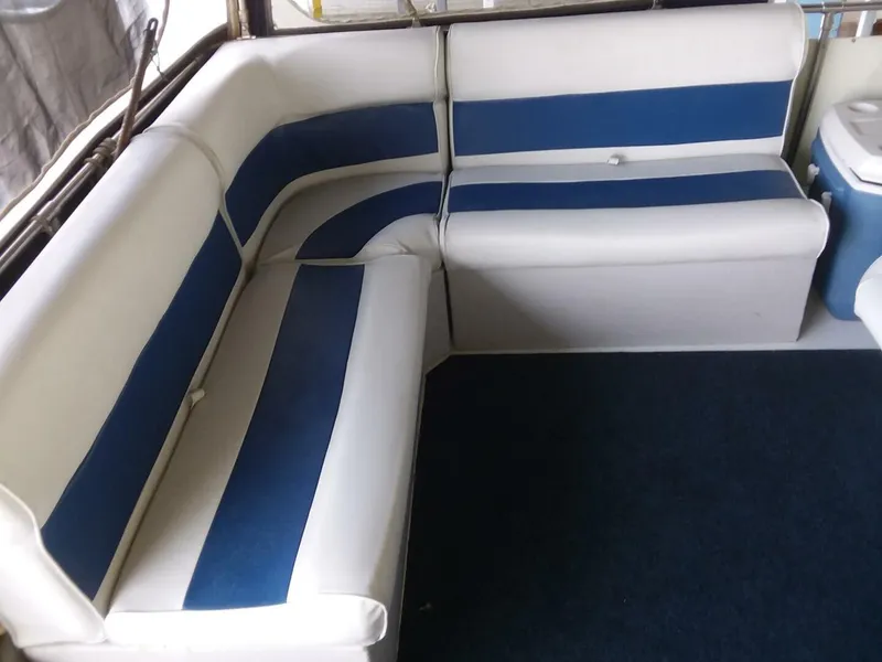 Slide: The Image of The interior view shows a white and blue cushioned corner bench on a boat. - 21