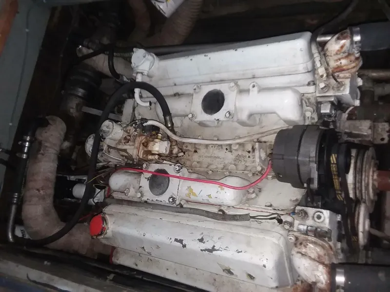 Slide: The Image of An engine compartment with a white engine block and various hoses and cables. - 15