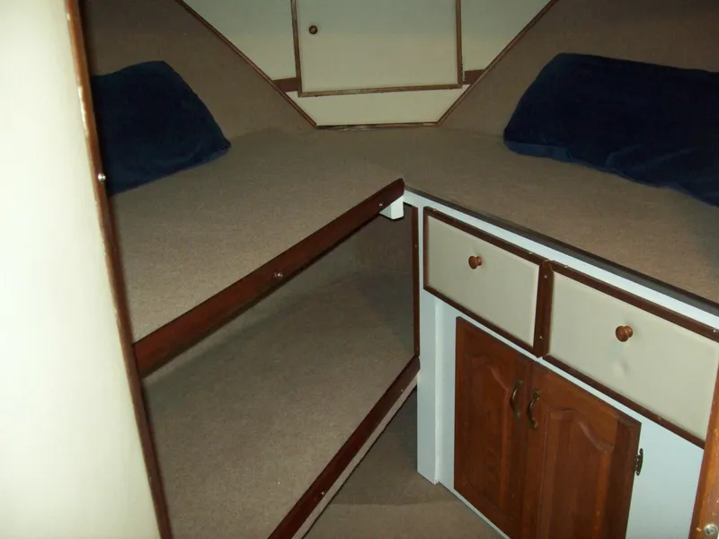 Slide: The Image of The 1979 Chris-Craft 350 Catalina cabin features two bunk beds and a cabinet. - 10