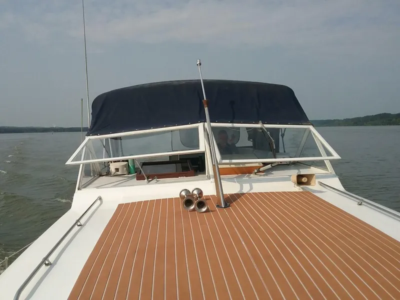 Slide: The Image of A 1979 Chris-Craft 350 Catalina cruising on calm waters. The boat features a blue canopy. - 22