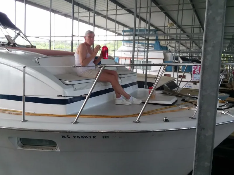 Slide: The Image of A man sits on a Chris-Craft 350 Catalina boat in a covered dock. - 19