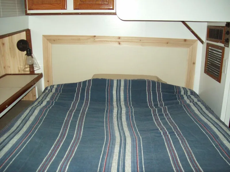 Slide: The Image of The image shows a cozy cabin with a striped bedspread and wooden furnishings. - 8