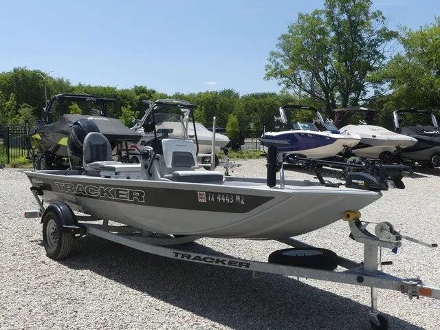 Slide: The Image of A gray Tracker Bass Tracker Classic CC boat from 2026 sits on a trailer in a gravel lot. - 7