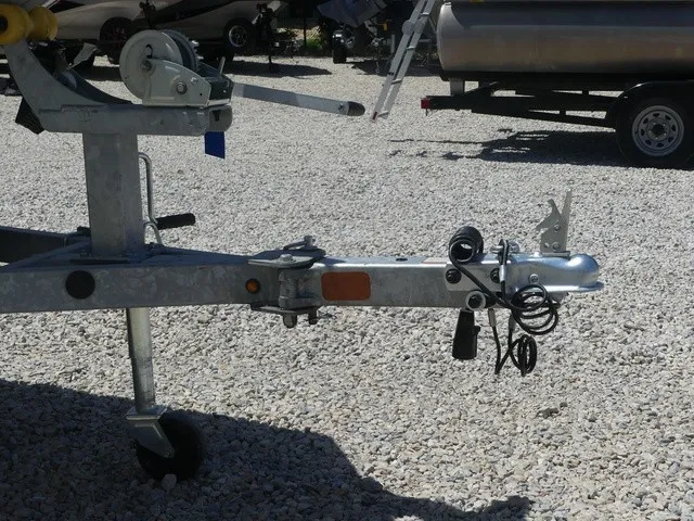 Slide: The Image of Trailer with winch and hitch on gravel surface. - 9