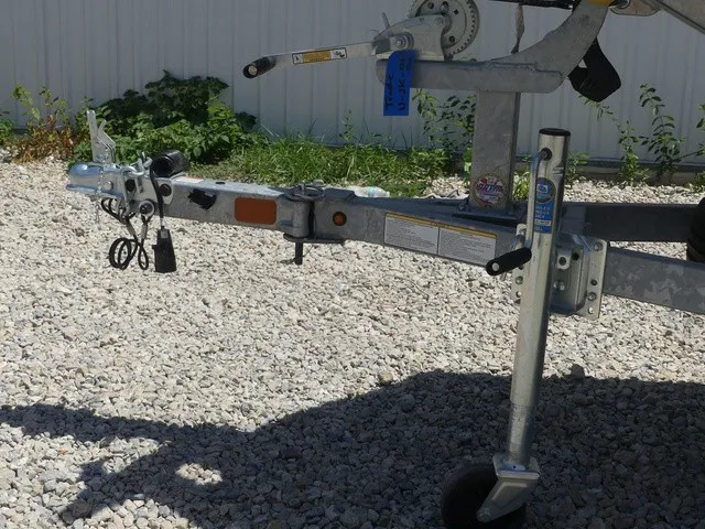 Slide: The Image of A boat trailer on a gravel lot, featuring a winch and a support wheel. - 10