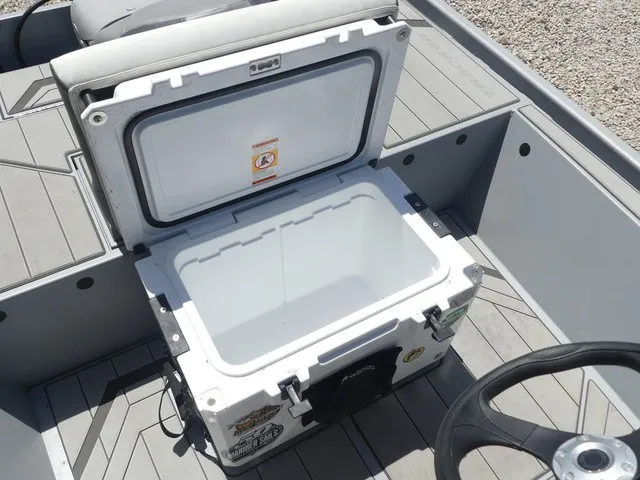 Slide: The Image of An open cooler on a boat with a gray floor and a steering wheel nearby. - 19