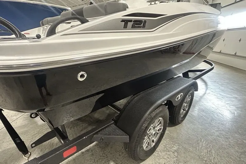 Slide: The Image of 2026 Tahoe T21 boat on trailer, sleek black and white design in indoor setting. - 3