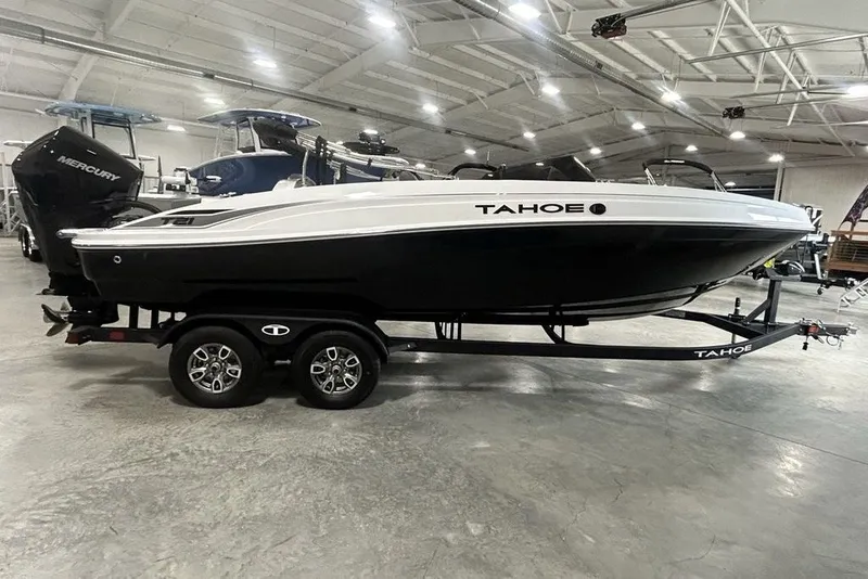 The Image of 2026 Tahoe T21 boat on trailer in showroom, featuring sleek black and white design. - 1