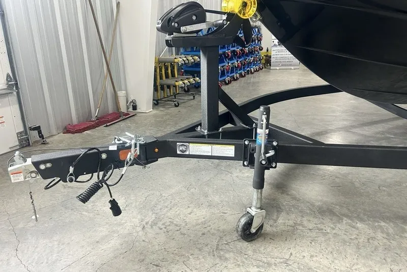 Slide: The Image of Trailer hitch and wheel assembly of a 2026 Tahoe T21 boat in a garage setting. - 5