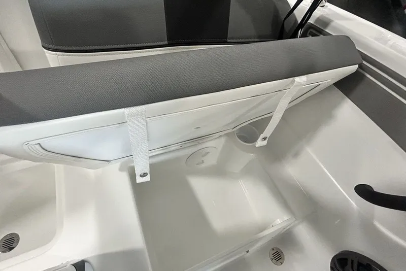 Slide: The Image of 2026 Tahoe T21 boat storage compartment with open seat and gray cushion. - 16