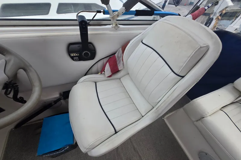 Slide: The Image of 1998 Bayliner 2655 Ciera cockpit with white captain's chair and steering wheel. - 13
