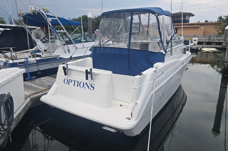 Slide: The Image of 1998 Bayliner 2655 Ciera boat docked, featuring blue canopy and "OPTIONS" on the stern. - 8