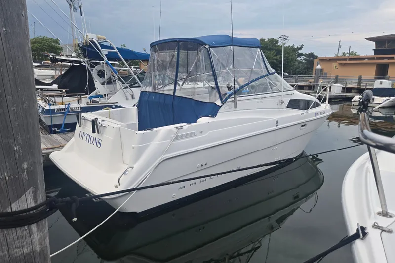 The Image of 1998 Bayliner 2655 Ciera boat docked in marina with blue canopy. - 9