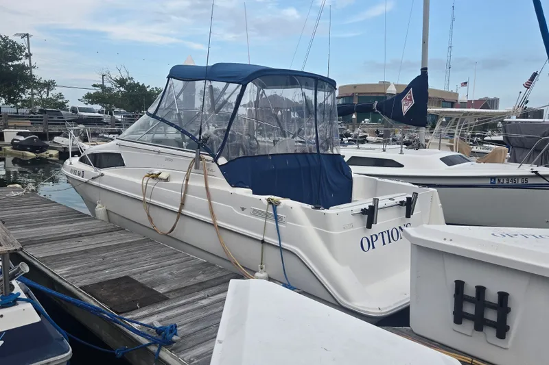 Slide: The Image of 1998 Bayliner 2655 Ciera docked at marina, featuring blue canopy and sleek design. - 0