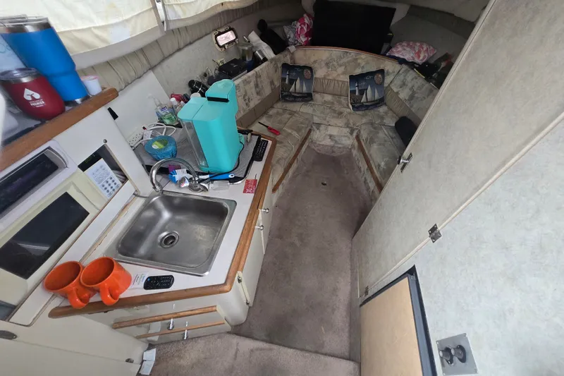 Slide: The Image of Interior of a 1998 Bayliner 2655 Ciera boat with kitchenette and seating area. - 1