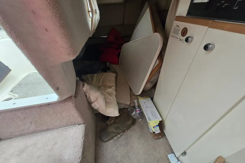 Slide: The Image of Interior of a 1998 Bayliner 2655 Ciera boat with cluttered cabin space. - 21