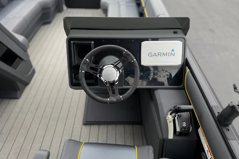 Slide: The Image of 2025 Manitou EXPLORE 24 boat dashboard with Garmin navigation system and steering wheel. - 26