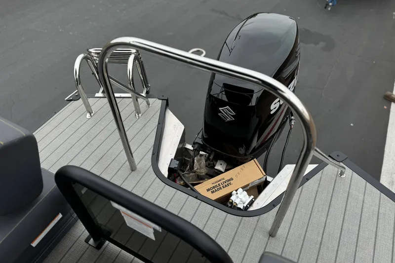 Slide: The Image of 2025 Manitou EXPLORE 24 boat with Suzuki outboard motor on deck. - 18