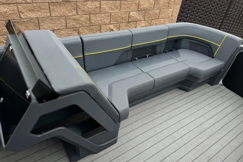 Slide: The Image of Modern seating on 2025 Manitou EXPLORE 24 boat, featuring sleek gray upholstery and yellow accents. - 11