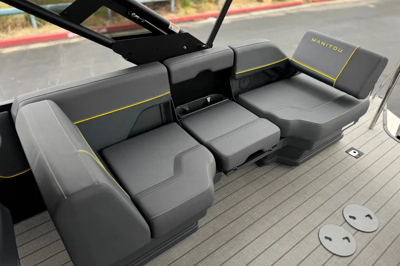 Slide: The Image of 2025 Manitou EXPLORE 24 boat seating with sleek gray upholstery and yellow accents. - 15