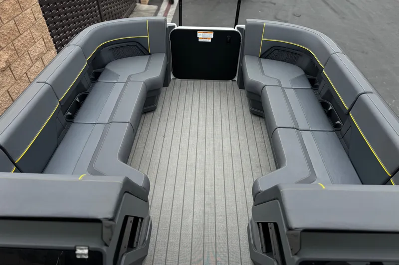 Slide: The Image of 2025 Manitou EXPLORE 24 boat interior with sleek gray seating and yellow accents. - 10