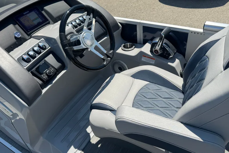 Slide: The Image of 2023 Bennington 23 LX STERN RADIUS boat helm with steering wheel and control panel. - 19