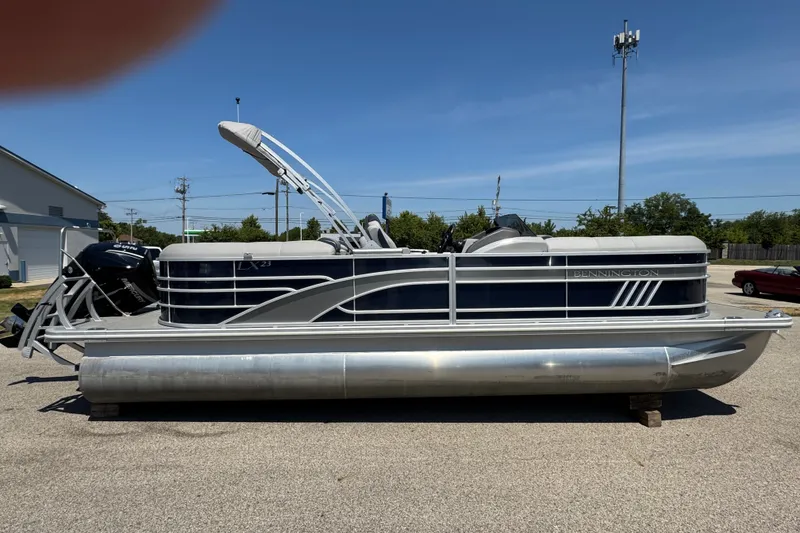 Slide: The Image of 2023 Bennington 23 LX STERN RADIUS pontoon boat parked outdoors on a sunny day. - 24