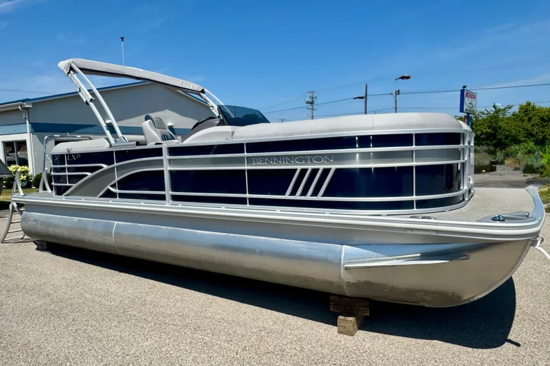 Slide: The Image of 2023 Bennington 23 LX STERN RADIUS pontoon boat on display outdoors. - 4