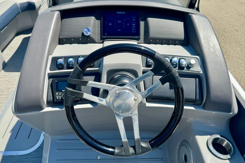 Slide: The Image of 2023 Bennington 23 LX STERN RADIUS boat dashboard with steering wheel and controls. - 6