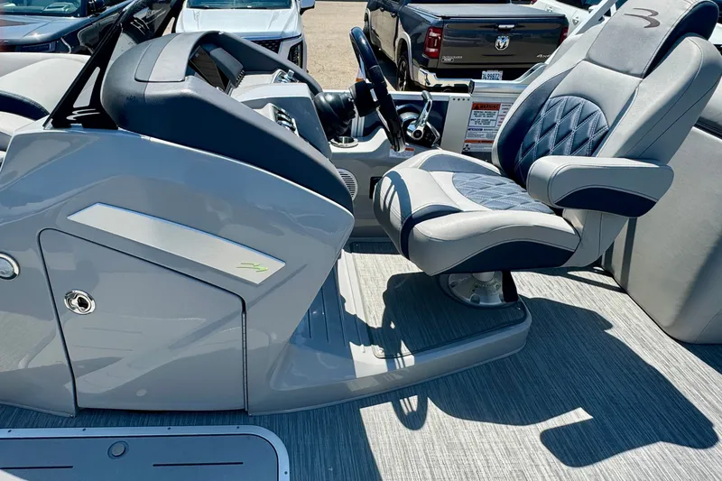 Slide: The Image of 2023 Bennington 23 LX STERN RADIUS boat interior with luxury captain's chair and sleek dashboard. - 8