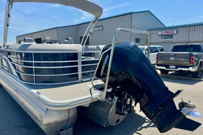 Slide: The Image of 2023 Bennington 23 LX STERN RADIUS pontoon boat with Mercury outboard motor, parked outdoors. - 27
