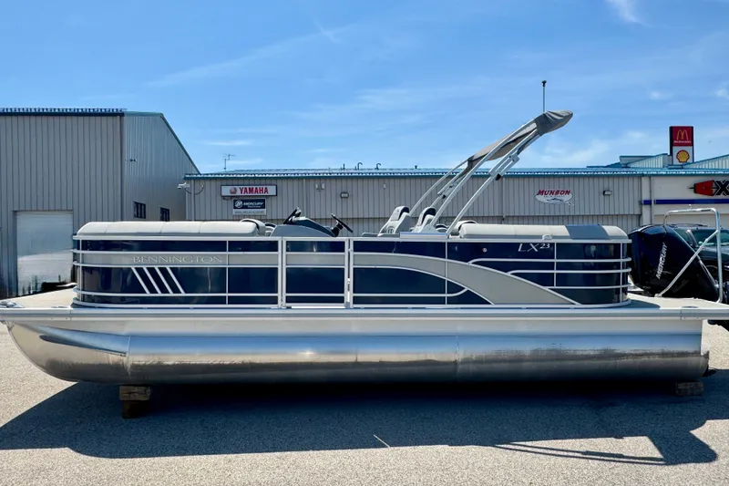 Slide: The Image of 2023 Bennington 23 LX STERN RADIUS pontoon boat displayed outdoors. - 1