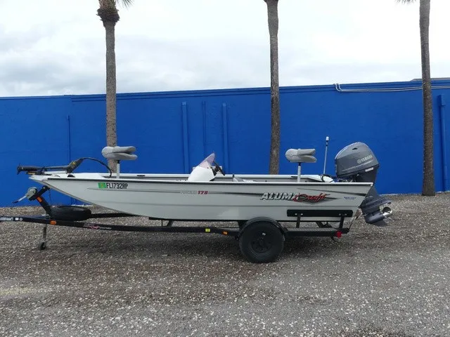 Slide: The Image of A 2018 Alumacraft 175 PROWLER boat on a trailer, parked in front of a blue wall. - 8