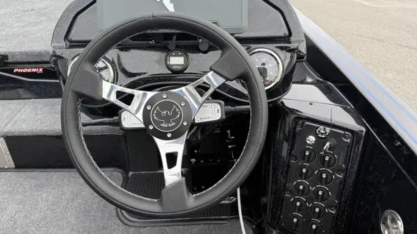 Slide: The Image of The image shows the cockpit of a 2027 Phoenix 921 Elite X boat with a modern steering wheel. - 20