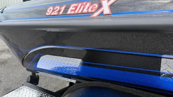 Slide: The Image of Close-up of a Phoenix 921 Elite X boat hull with glossy black and blue paint. - 4