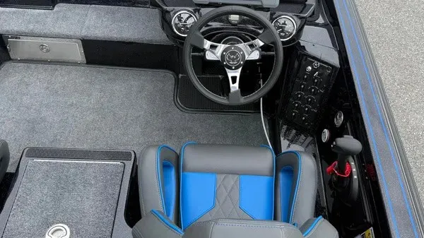Slide: The Image of The image shows the cockpit of a 2027 Phoenix 921 Elite X boat with a modern steering wheel and blue accents. - 19