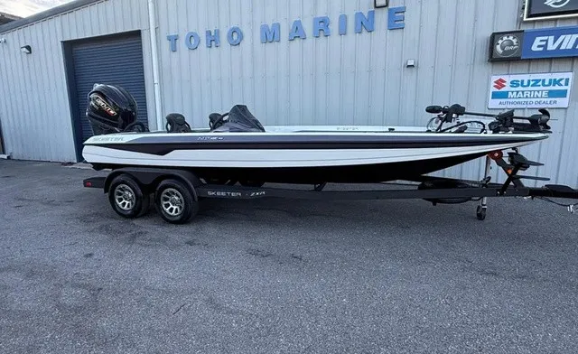 The Image of A white Skeeter ZXR21 SE boat from 2026 on a trailer in front of a building. - 1