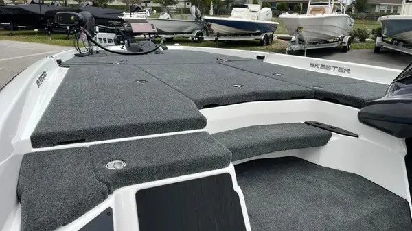 Slide: The Image of The image shows the deck of a 2026 Skeeter ZXR21 SE boat with gray carpeting. - 7