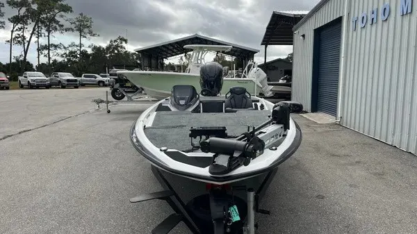Slide: The Image of A modern 2026 Skeeter ZXR21 SE is parked in a lot. Boats and buildings are visible in the background. - 5