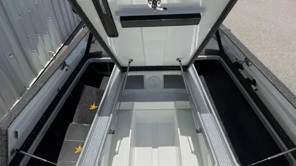 Slide: The Image of The image shows the open storage compartment of a 2027 Phoenix 721 ZXL boat with gray details. - 18