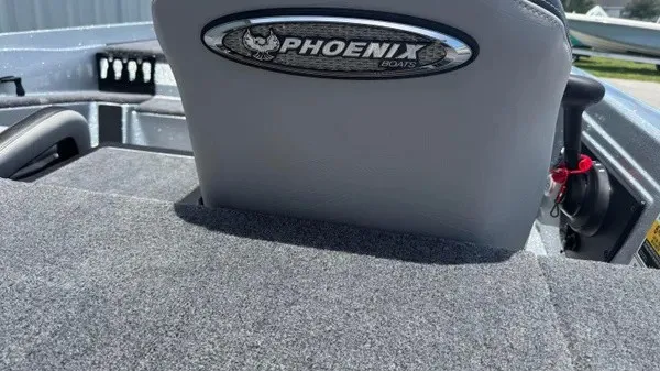 Slide: The Image of Rear view of a gray boat seat with Phoenix logo, surrounded by gray carpeting. - 25