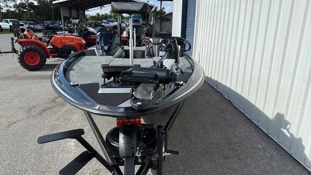 Slide: The Image of A modern boat with a gray deck and black hull sits on a trailer next to a building. - 8