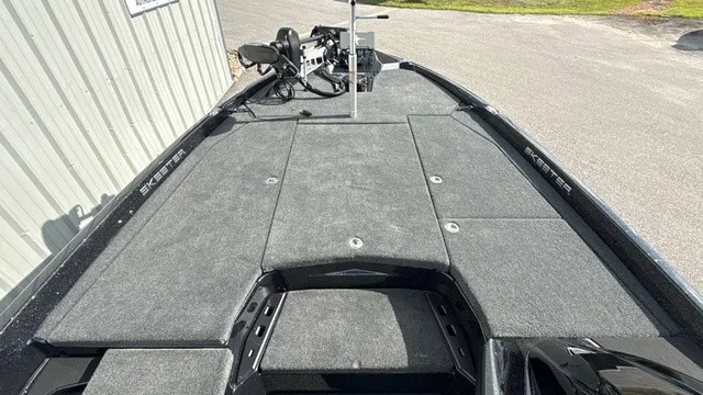 Slide: The Image of The image shows the deck of a 2027 Skeeter ZXE20 boat with gray carpeting. - 15